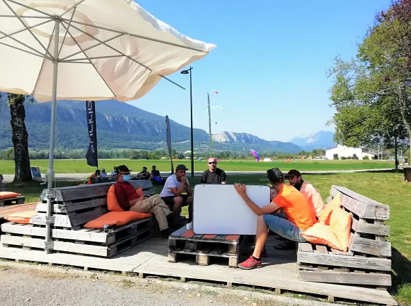 Un instructeur de parapente instruit des pilotes au passage des brevets, en extérieur sur la terrasse Flyeo